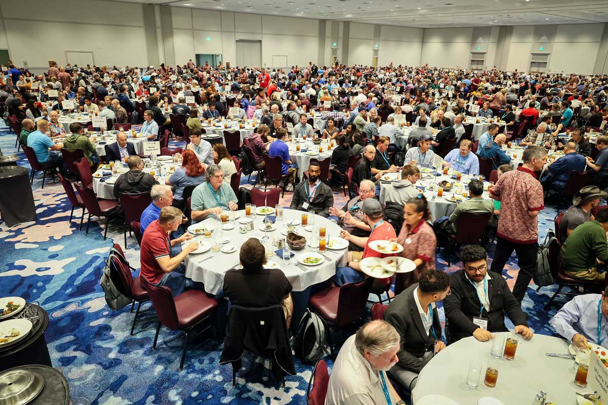 A ballroom of Live! 360 attendees at the Table Topics Lunch, seated at round tables each marked with a printed topic sign.